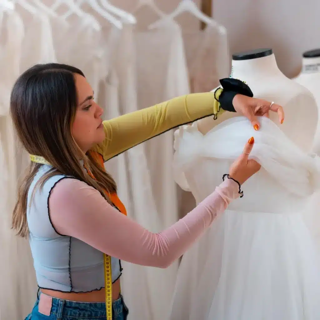 Wedding dress alterations in progress with a tailor adjusting a bridal gown on a mannequin