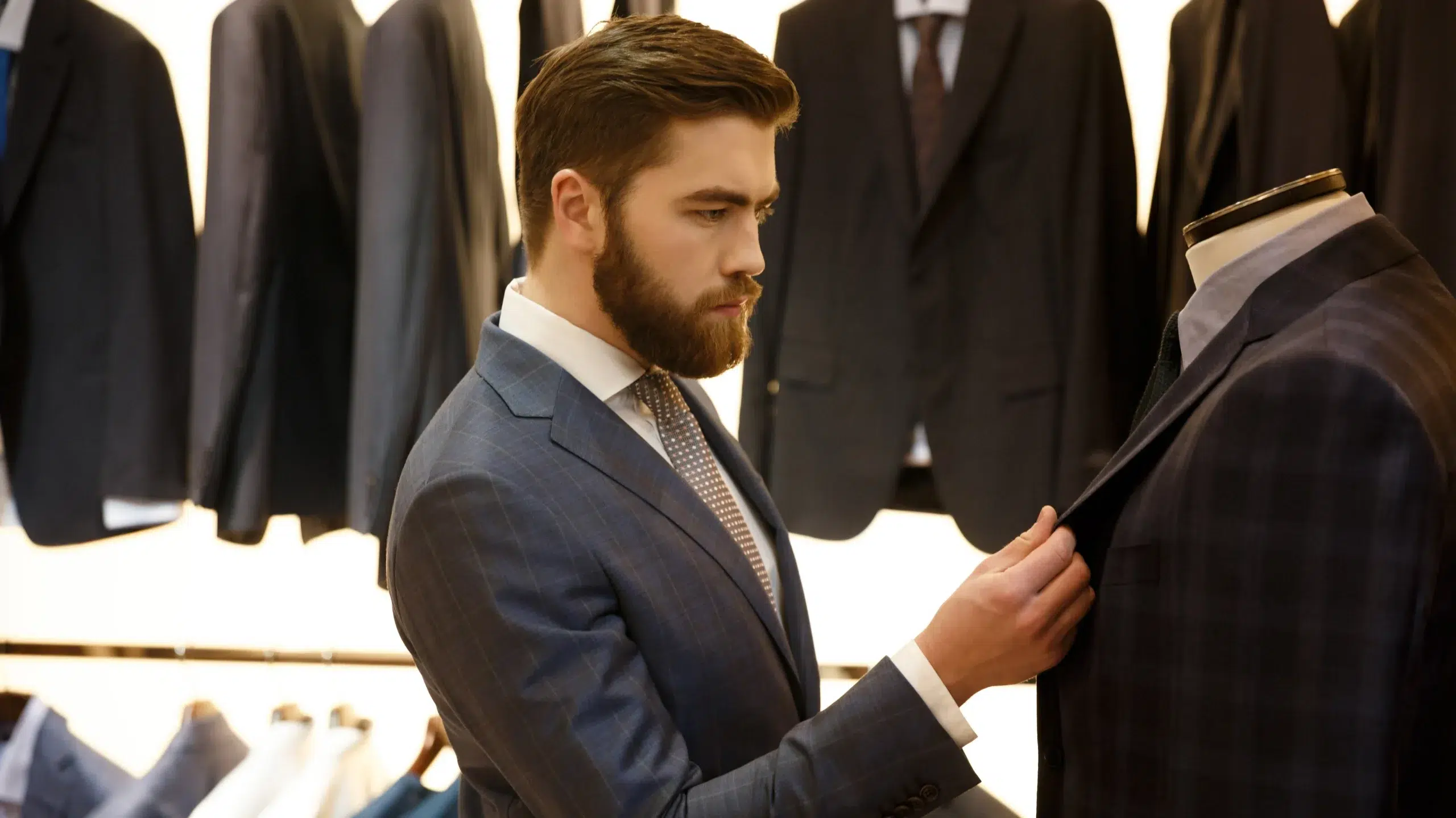 Man examining bespoke suit jacket at City Tailors, showcasing modern suit styles for gentlemen